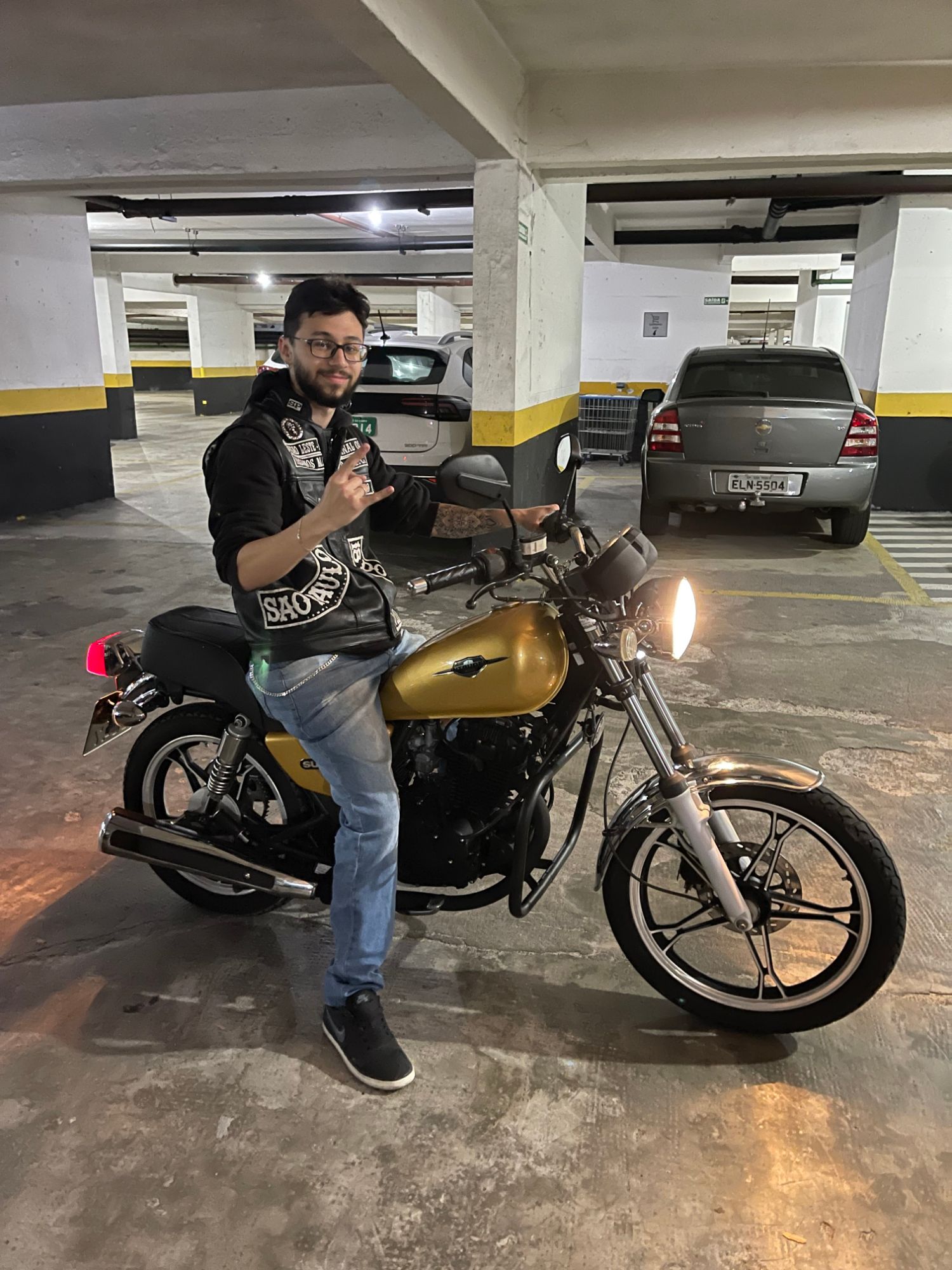Lucas Takano com moto clássica na garagem